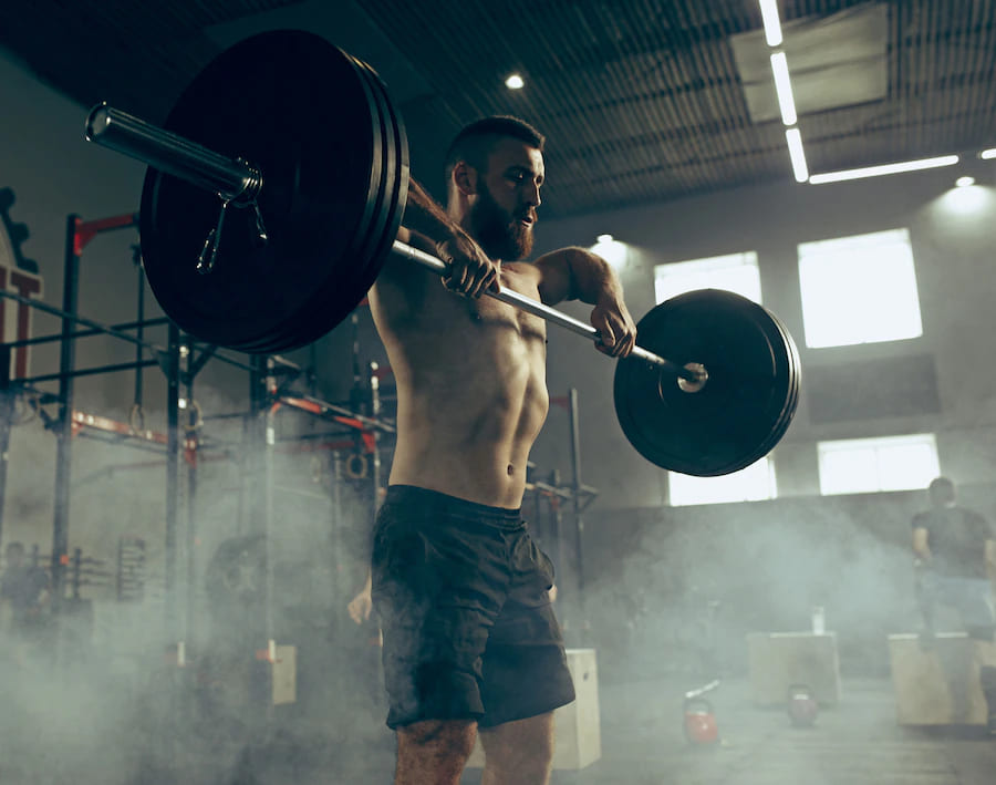 caber jovem levantando halteres malhando em uma academia 155003 4894