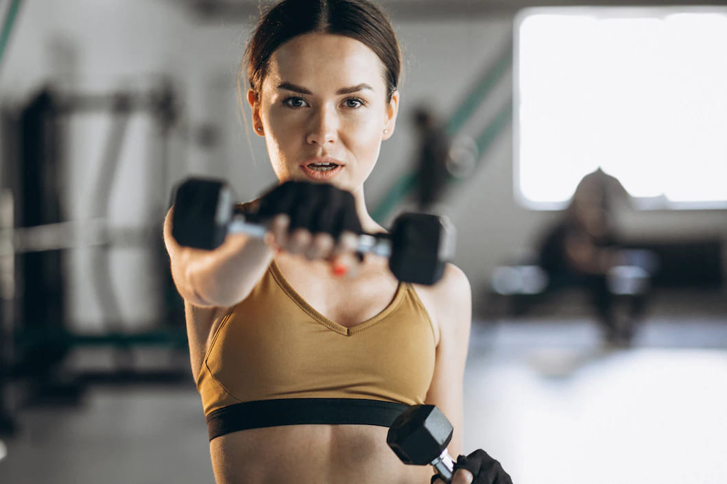 mulher jovem e atraente exercitar com halteres na academia 1303 22609