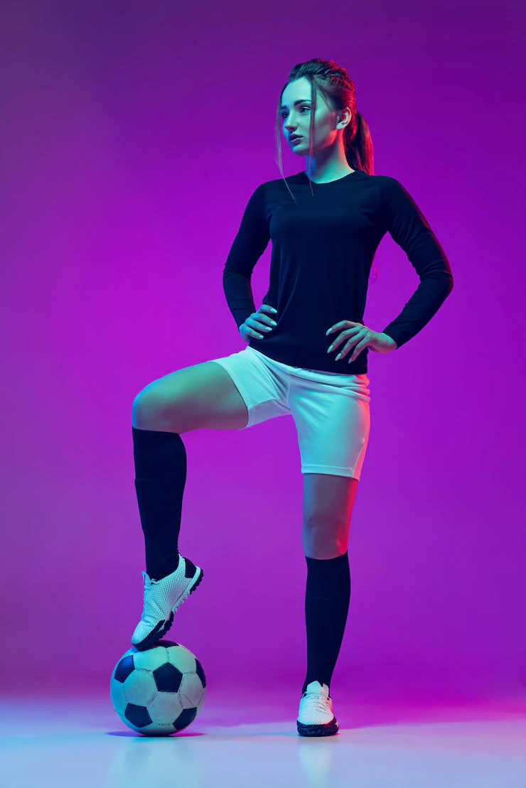 retrato de jogadora de futebol profissional feminina posando de uniforme com bola isolada sobre fundo roxo em neon 155003 45623