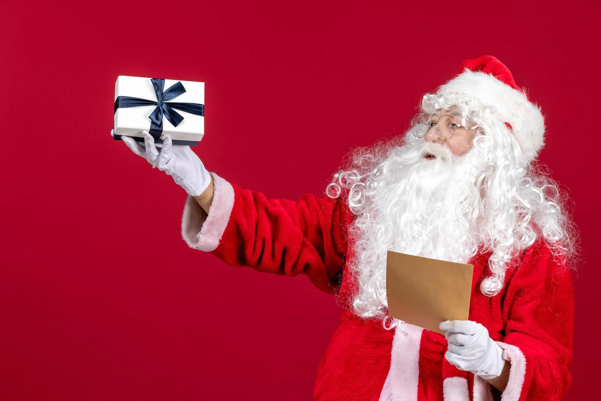 papai noel lendo uma carta de uma crianca e segurando um presente de emocoes vermelhas no feriado de